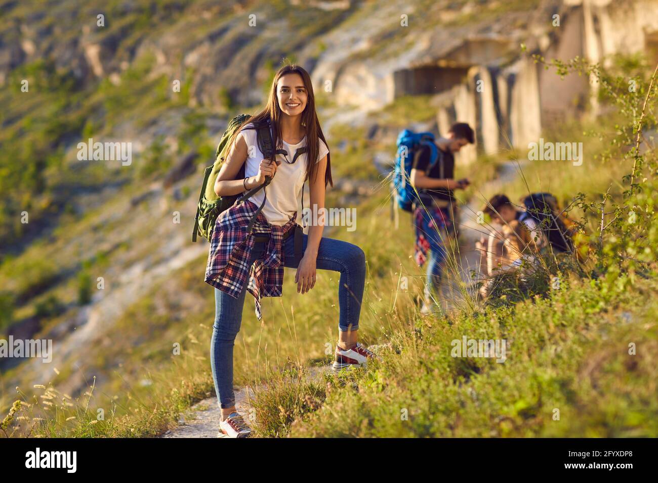 Porträt einer glücklichen und lächelnden Wanderin mit Rucksack beim Wandern in den Bergen. Stockfoto