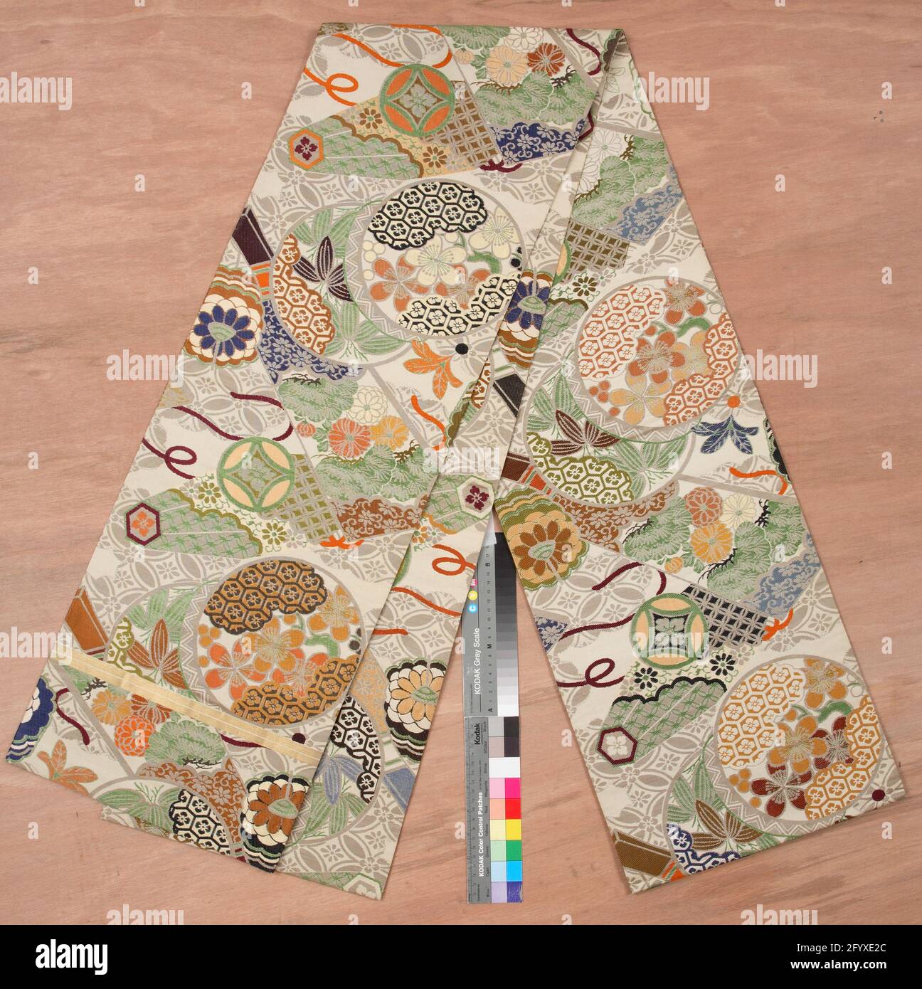 Frauen Maru Obi mit geometrischen und pflanzlichen Motiven. Seidenbrokatgürtel für einen formellen Kimono (Maru obi) für eine Frau, mit einem Ornament über den gesamten Bereich von ​​different geometrischen Motiven und Kiefer, Chrysantheme, prunus und anderen floralen Motiven, in Kreis- und fächerförmigen Oberflächen. Cremeweiße Seide mit Brokat-Strukturverzierung (Nishiki). Stockfoto