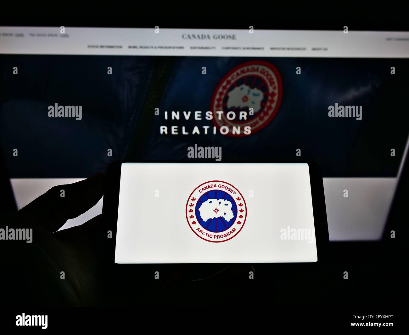 Person, die das Smartphone mit dem Logo des Winterbekleidungsunternehmens Canada Goose Holdings auf dem Bildschirm vor der Business-Website hält. Konzentrieren Sie sich auf die Telefonanzeige. Stockfoto