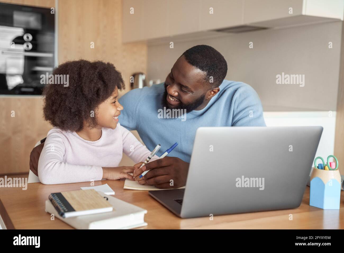 Glückliche junge Eltern Vater helfen Kind Tochter mit Fernunterricht Von zu Hause aus Stockfoto