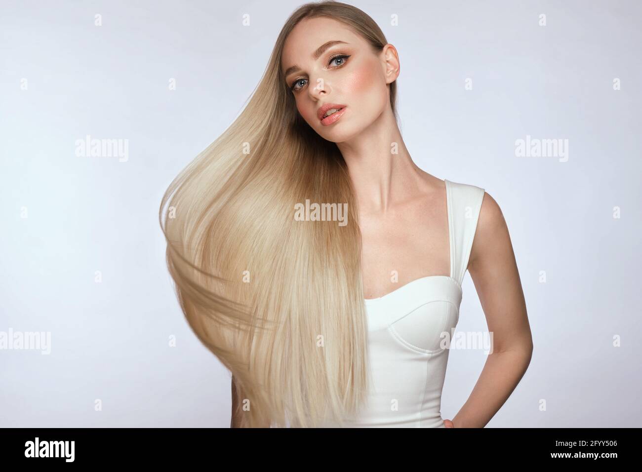 Schöne blonde Mädchen mit einem perfekt glatten Haar und klassischen Make-up. Schönheit Gesicht und Haare. Stockfoto
