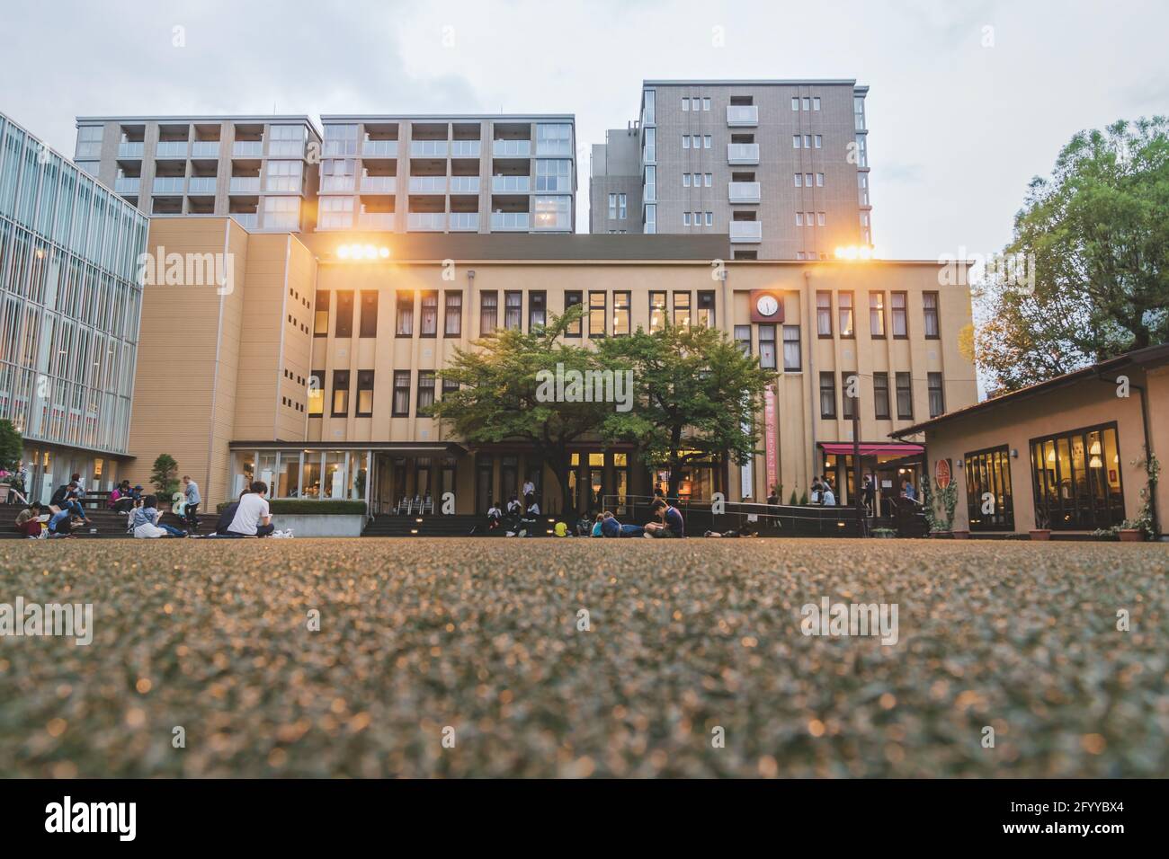 Kyoto, Japan - 17. September 2017: Besucher und Studenten sitzen auf dem Boden und auf Treppen und lesen am Abend auf einem beleuchteten Hinterhof im International Manga Muse Stockfoto