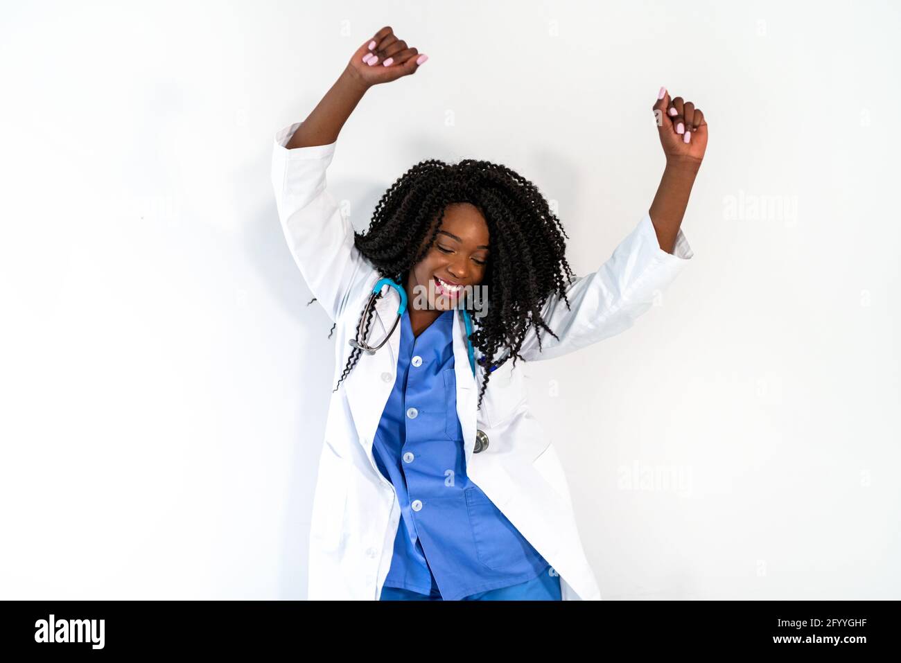 Afroamerikanische Frau in medizinischer Uniform tanzt in der Arztpraxis während der Pause Stockfoto