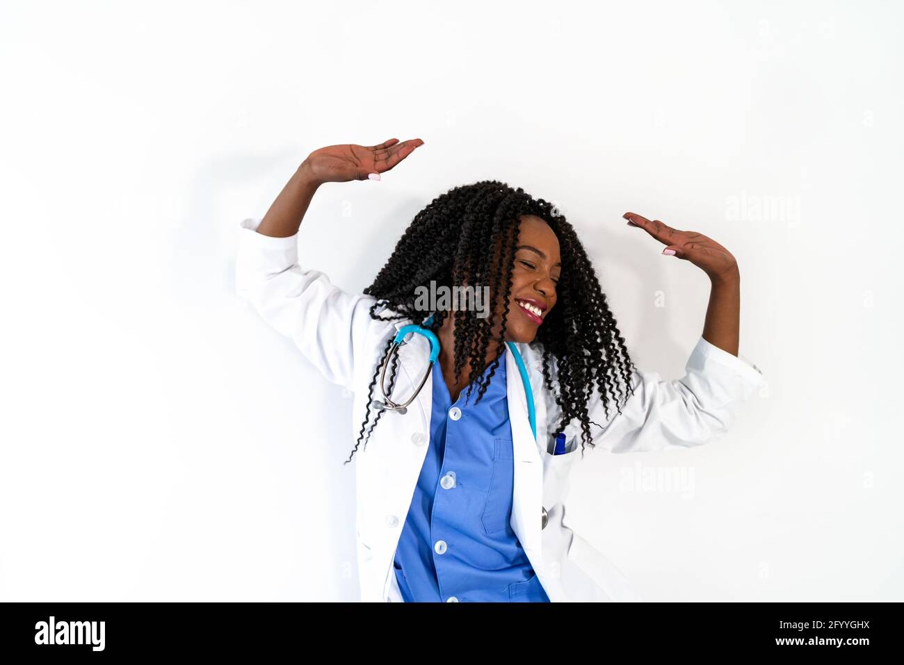 Afroamerikanische Frau in medizinischer Uniform tanzt in der Arztpraxis während der Pause Stockfoto