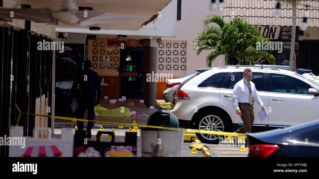 Hialeah, Usa. Mai 2021. Zwei nicht identifizierte Leichen lagen mit gelben Planen bedeckt vor der El Mula Bankettsaal im Nordwesten von Miami-Dade County, in der Nähe von Hialeah, Florida, Sonntag, 30. Mai, 2021. Nummerierte Zapfen sind an ausgegebenen Schalengehäusen von auf den Tatort abgefeuerten Kugeln zu sehen. Der Bankettsaal wurde für ein Konzert vermietet und in den frühen Morgenstunden fuhr ein SUV in den Saal, drei Schützen kamen heraus, töteten zwei und verletzten mindestens 20 weitere Konzertbesucher. Foto von Gary i Rothstein/UPI. Kredit: UPI/Alamy Live Nachrichten Stockfoto