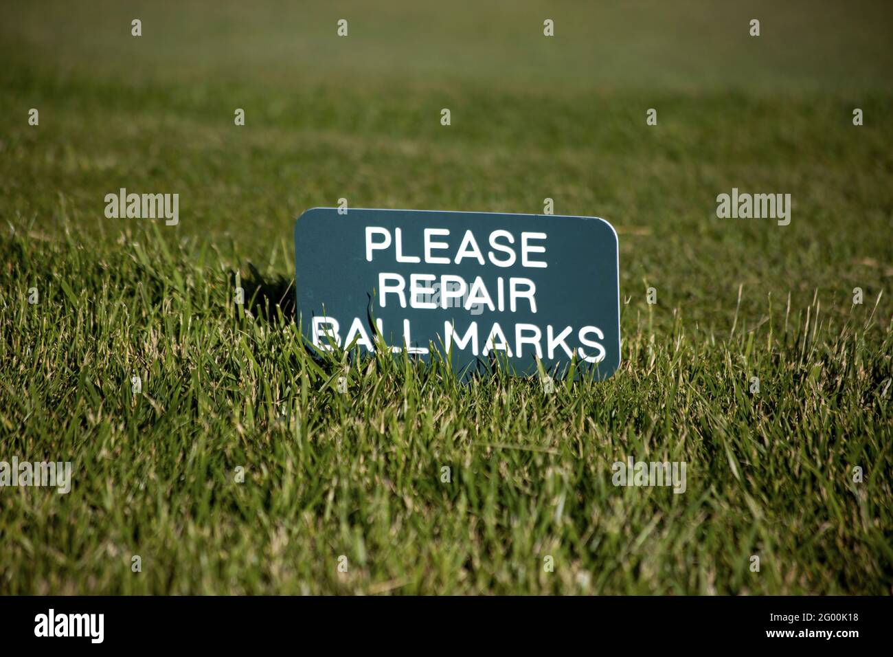 Schuss des Schildes vor dem Gras platziert bitten, um die Ball-Markierungen zu reparieren. Stockfoto