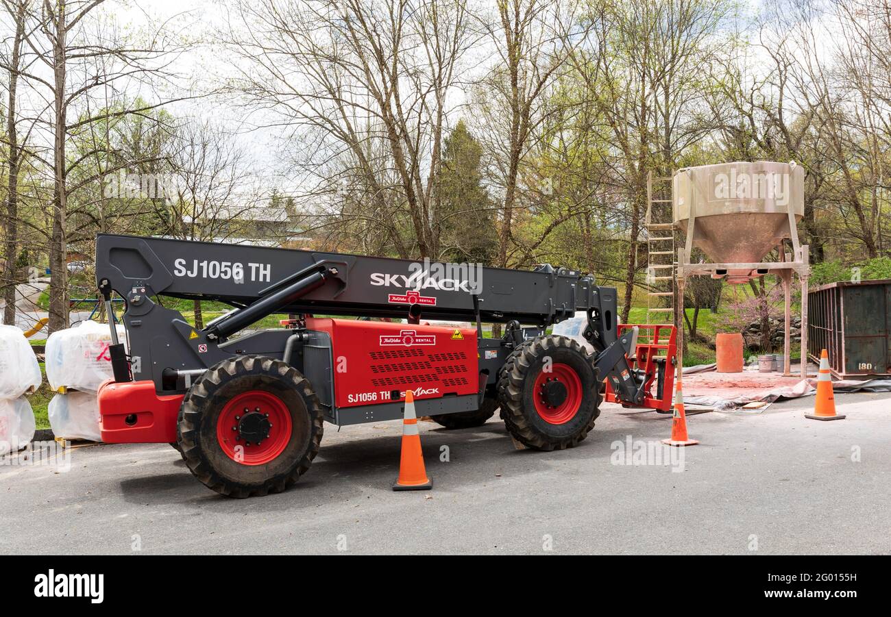 JONESBOROUGH, TN, USA--9. APRIL 2021: Industrielle Baumaschinen, einschließlich eines „Skyjack“-Aufzugs und eines Mörtelmischers. Stockfoto