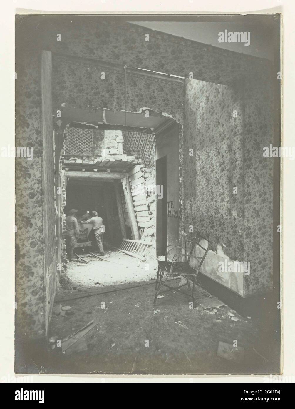 Arbeiter in einem Haus, das für den Bau einer Eisenbahn abgerissen wird,  Paris. Ein halb zerbrochener Raum mit floraler Tapete ist ein Stuhl, der  durch die offene Wand den Bau eines Tunnelrohrs