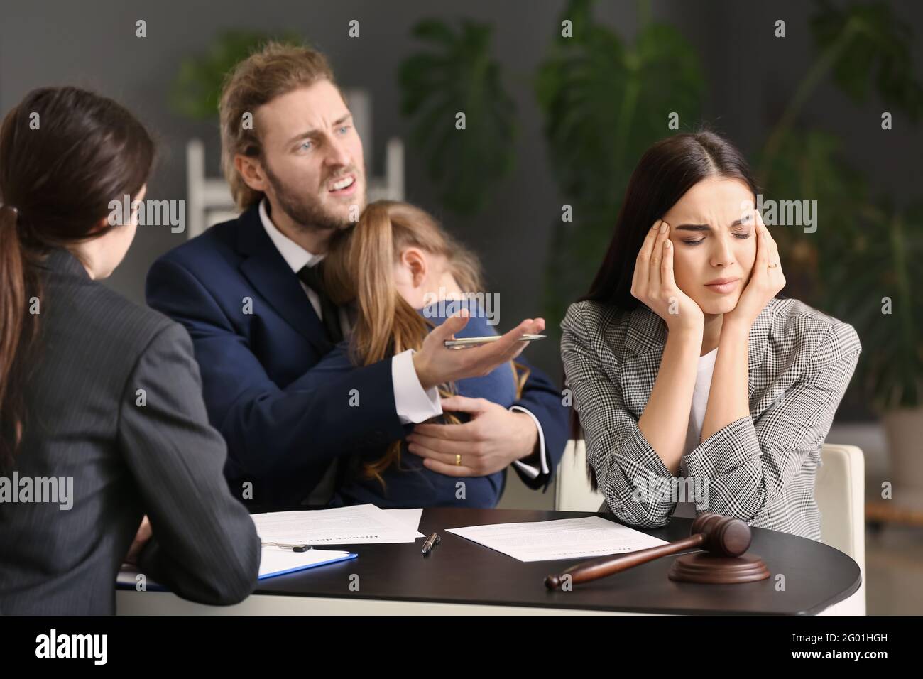 Das junge Paar und ihre Tochter besuchen den Scheidungsanwalt im Büro Stockfoto