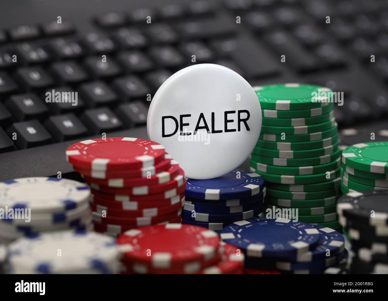 Dealer Chip auf Poker-Chips vor der Computer-Tastatur, Konzept Bild von Online-Casinos, Spielsucht Stockfoto