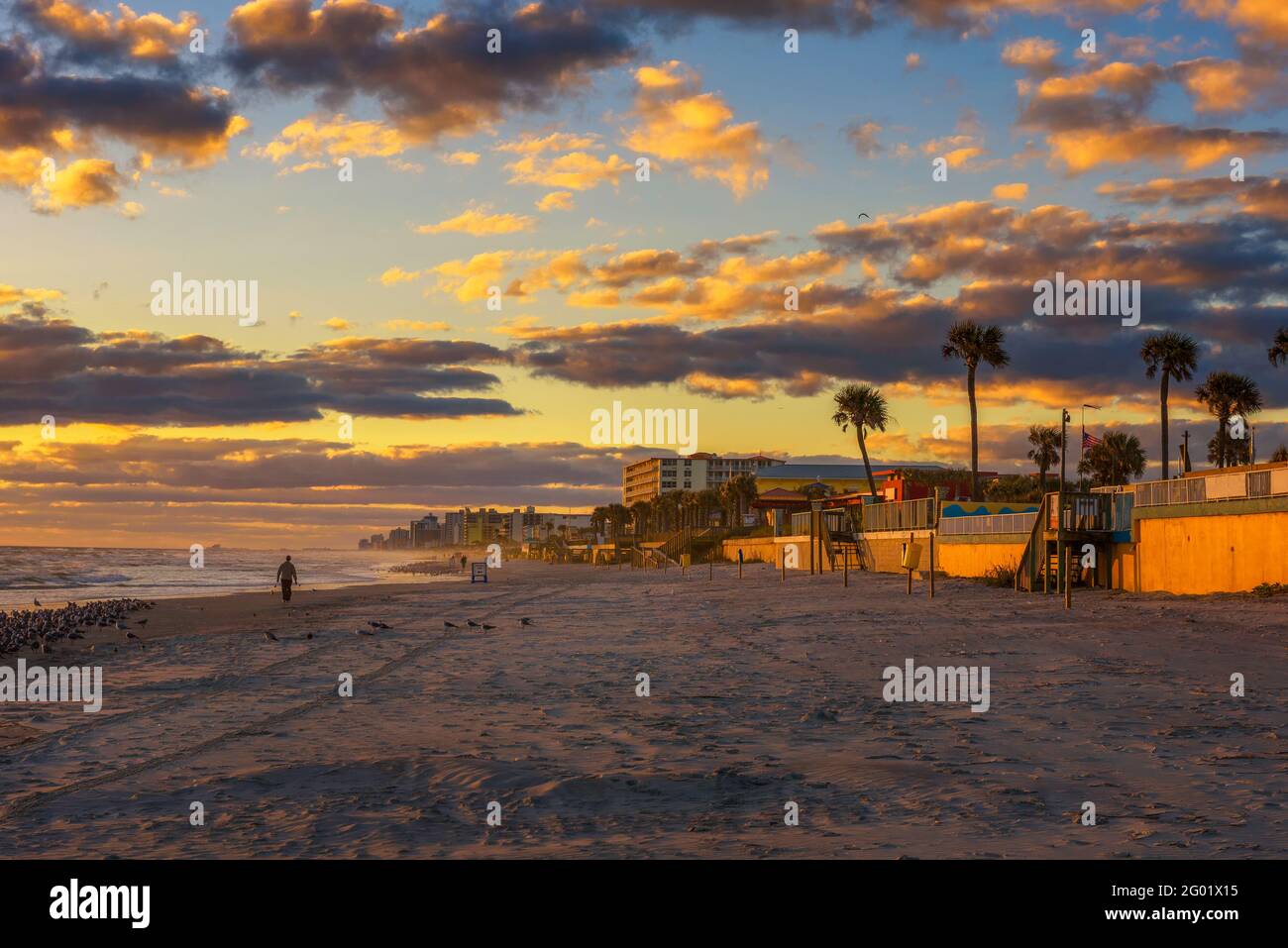 Küste von Dayona Beach in Florida bei Sonnenaufgang mit Menschen Und Palmen Stockfoto
