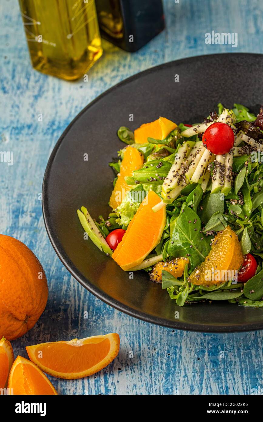 Purslane Salat mit Orange und Quinoa auf blauem Steingrund. Stockfoto