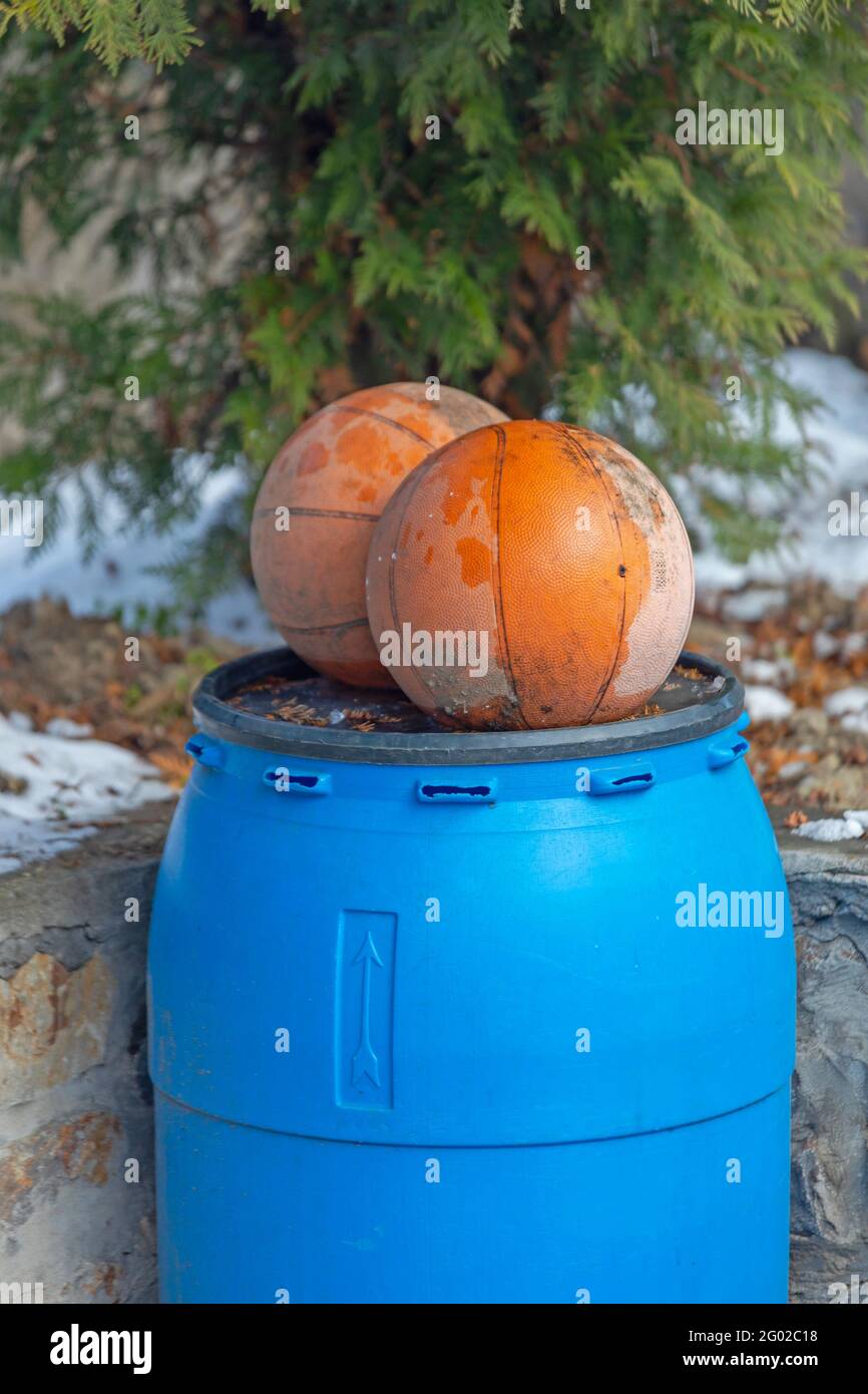 Zwei Basketbälle auf der Oberseite des blauen Plastikfass Stockfoto