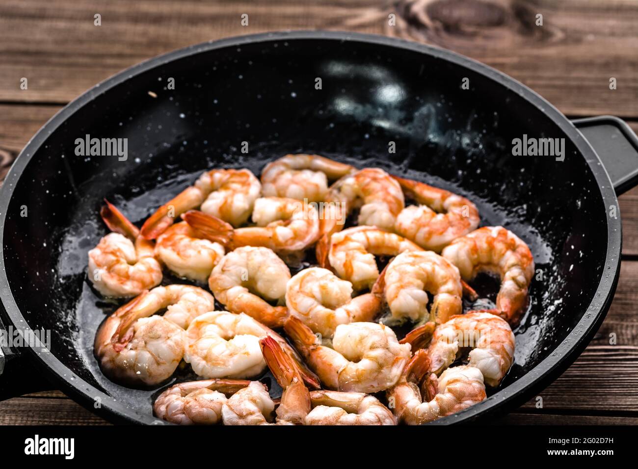 Gegrillte Garnelen auf der Pfanne, Zubereitung von Gericht mit Krustentieren, mediterranes Speisekonzept Stockfoto