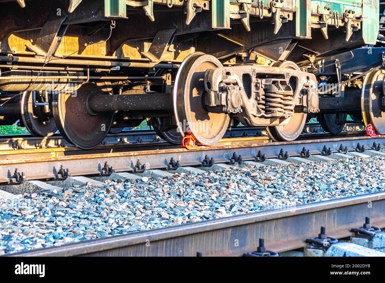 Innerhalb des Transportterminals steht auf den Versand ein Eisenbahngüterwagen mit einem Bremsschuh unter den Rädern auf den Gleisen Stockfoto