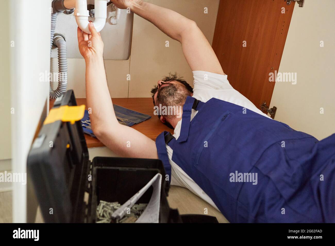 Heimwerker oder Klempner vom Notdienst reparieren einen Defekt Siphon im Spülbecken der Küche Stockfoto