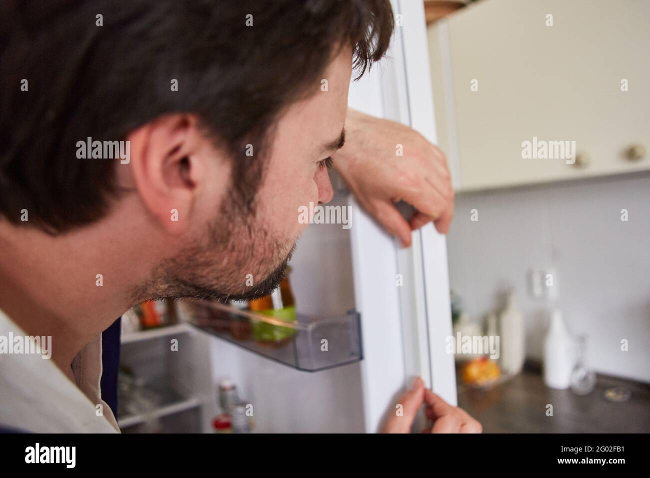 Heimwerker, der die defekte Dichtung an der Kühlschranktür ersetzt Stockfoto