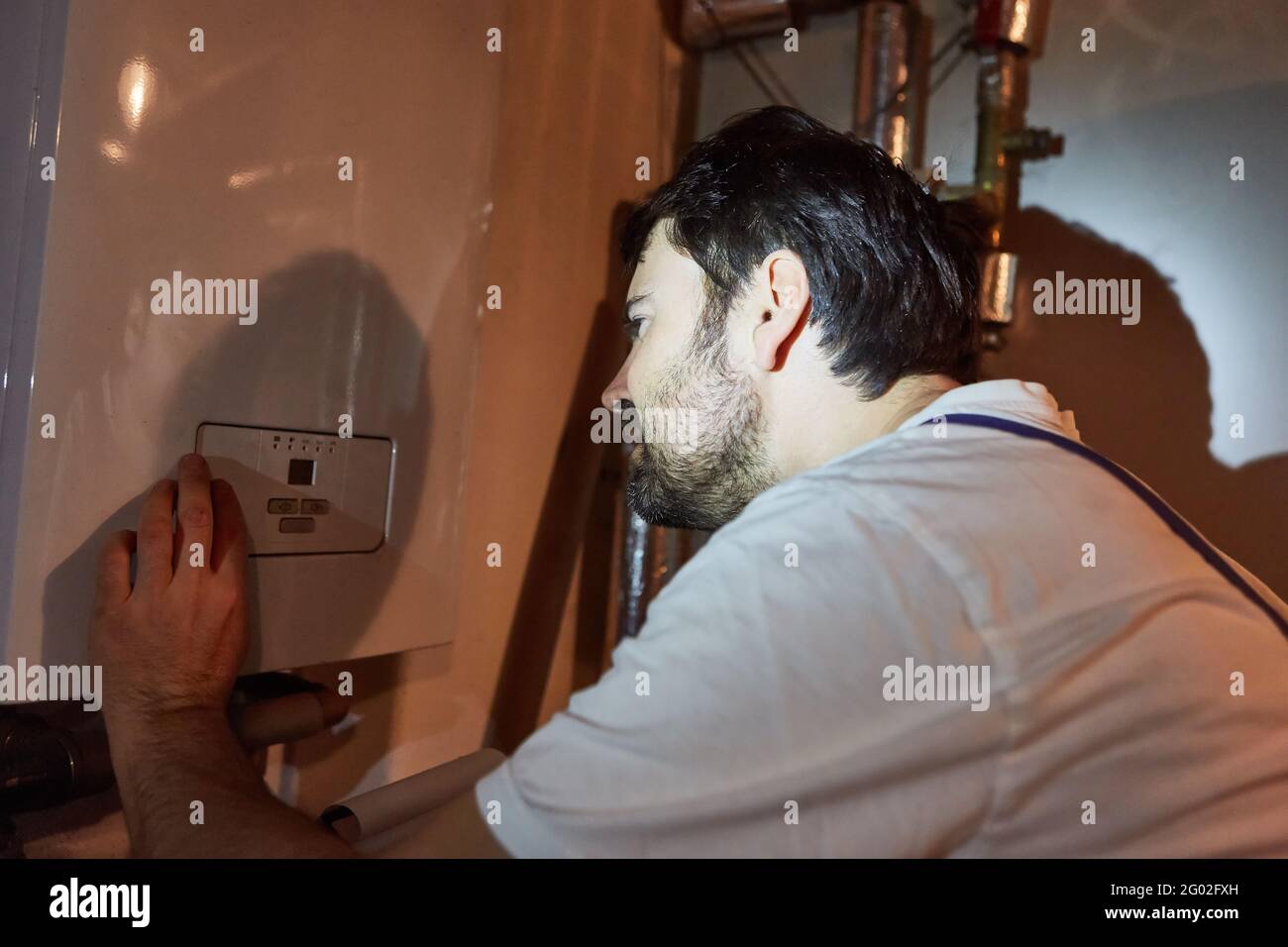 Der Heizungsinstalleur überprüft den Gaskessel im Untergeschoss Während der Heizungswartung Stockfoto