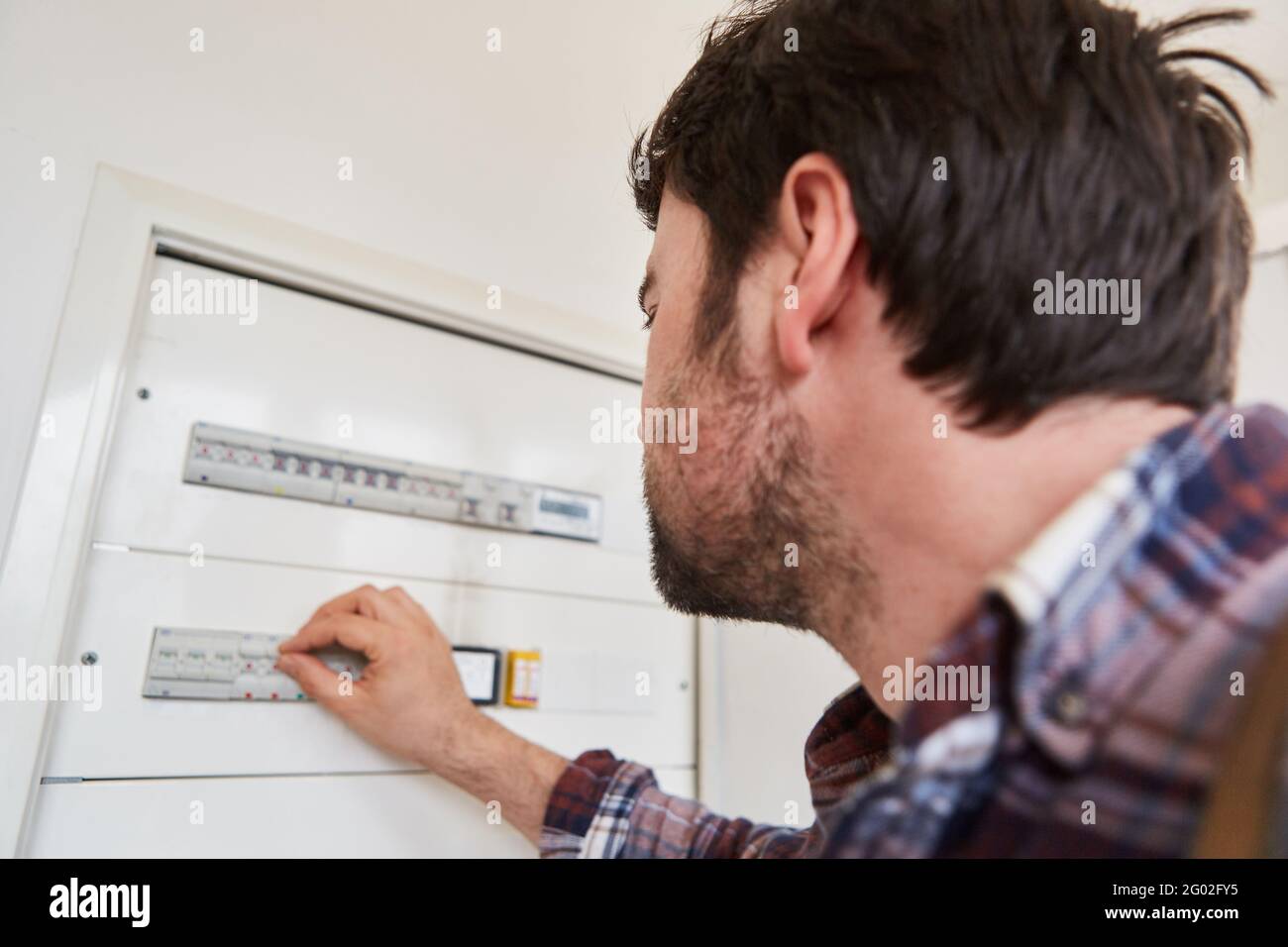 Der Elektriker steuert den Schalter für die Elektroinstallation in der Verteilung Feld Stockfoto