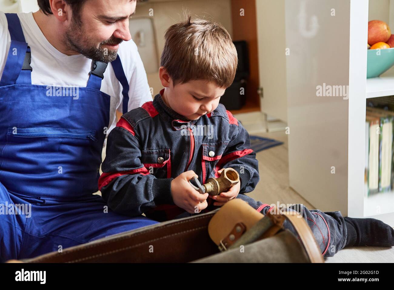 Vater und Sohn als Heimwerker mit defektem Absperrventil Oder Ersatzteil für die Montage Stockfoto