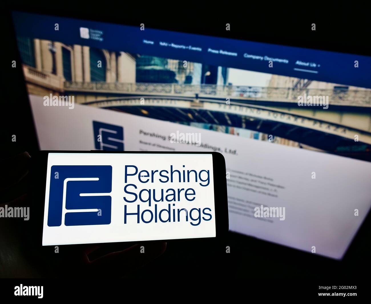 Person, die Mobiltelefon mit Logo der Firma Pershing Square Capital Management LP auf dem Bildschirm vor der Business-Website hält. Konzentrieren Sie sich auf die Telefonanzeige. Stockfoto