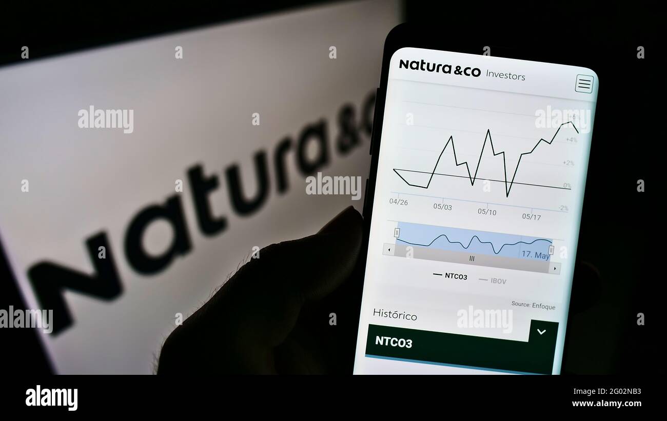 Person, die Mobiltelefon mit der Webseite des brasilianischen Körperpflegeunternehmens Natura Co Holding SA auf dem Bildschirm mit Logo hält. Konzentrieren Sie sich auf die Mitte des Telefondisplays. Stockfoto