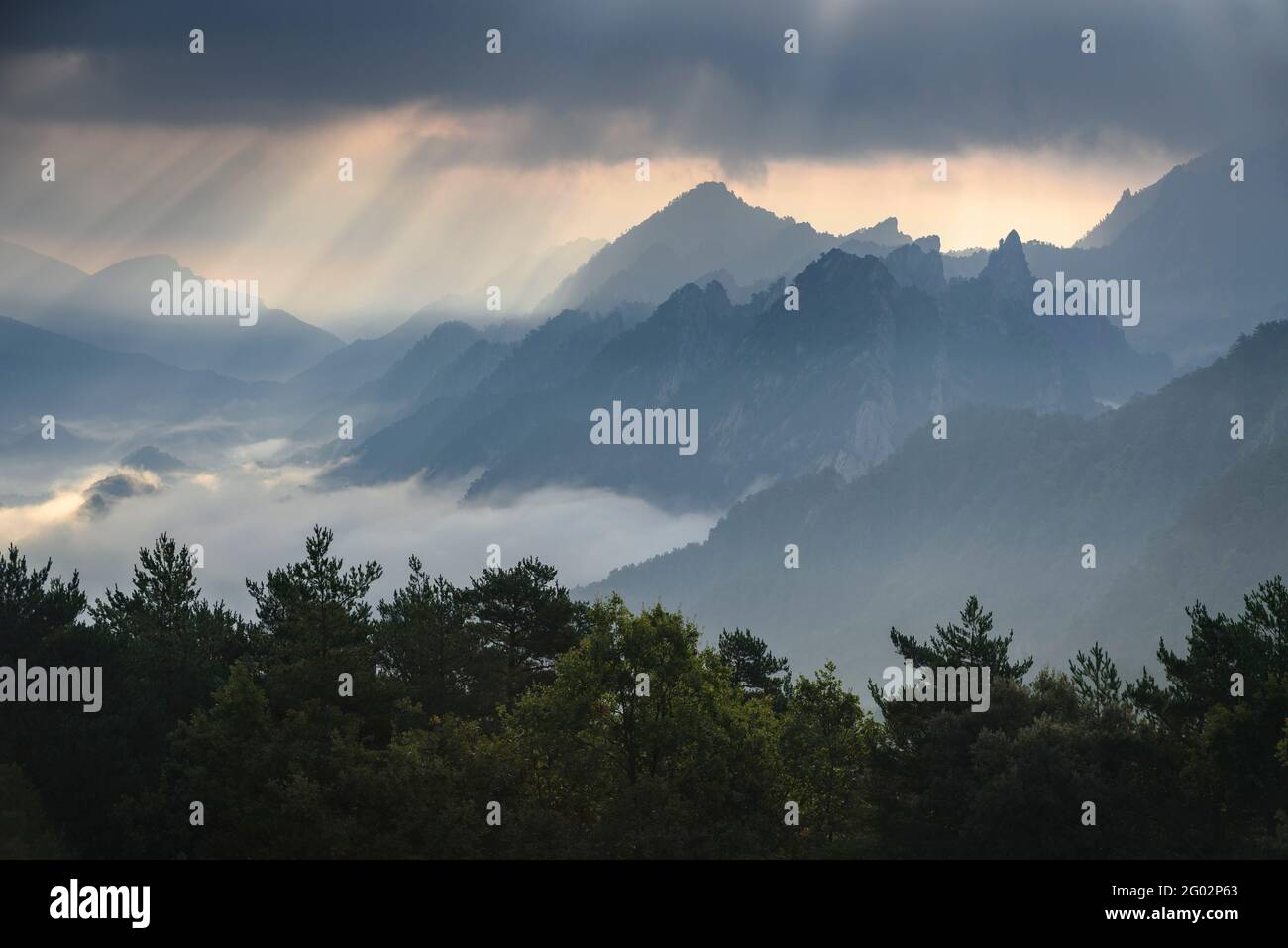 Serra de Bastets von der Nähe des Dorfes Sant Llorenç de Morunys aus gesehen, mit einigen Lichtstrahlen zwischen Wolken (Solsonès, Katalonien, Spanien, Pyrenäen) Stockfoto