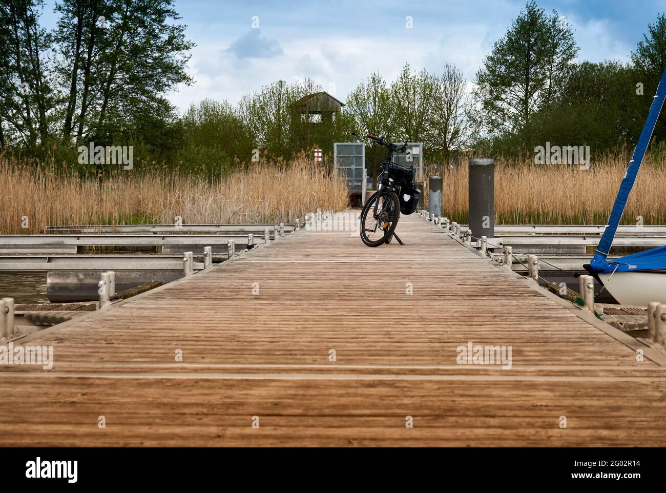 Holzplankenboot Dock mit einem Fahrrad geparkt während ein Radtour rund um den Arendsee in Deutschland Stockfoto