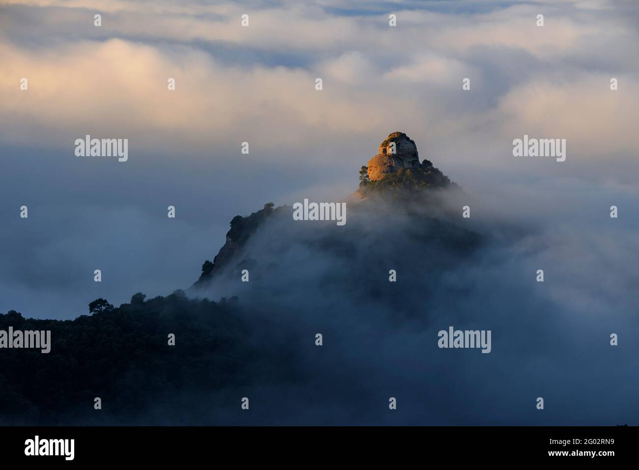 Der Felsen von Paller de tot l'Any bei Sonnenaufgang, umgeben von Nebel (Naturpark Sant Llorenç del Munt i l'Obac, Barcelona, Katalonien, Spanien) Stockfoto