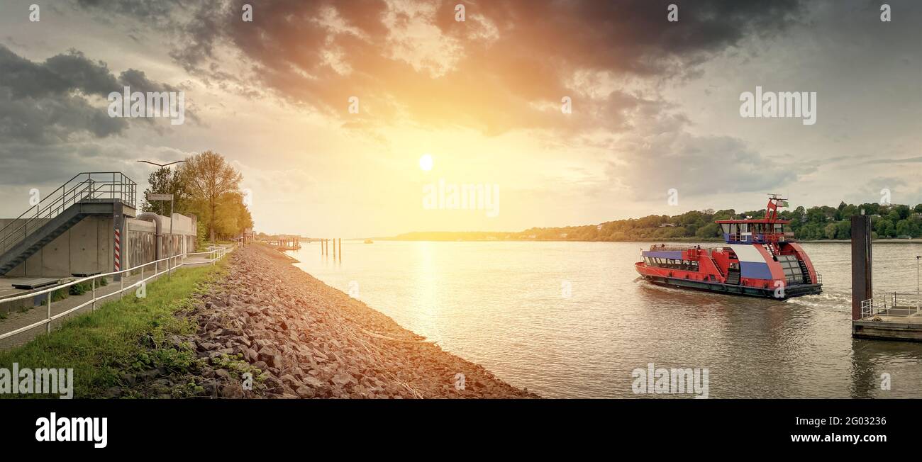 Sonnenuntergang über dem Fluss mit einer Fähre in der Nähe von Hamburg Stockfoto