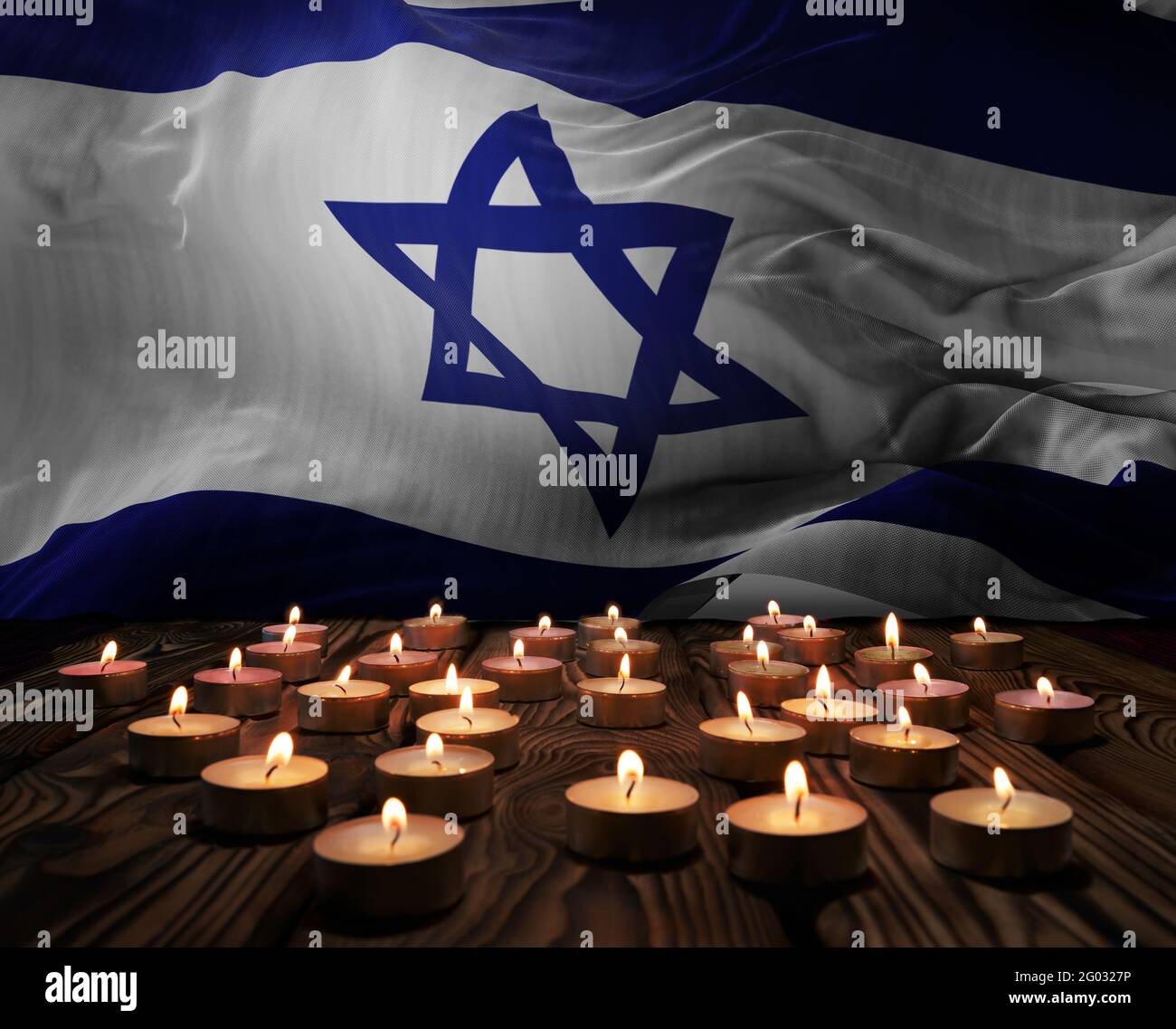 Trauerkerzen brennen auf der israelischen Nationalflagge des Hintergrundes. Memorial Weekend, Tag der Patrioten, Nationalfeiertag. Brennen c Stockfoto