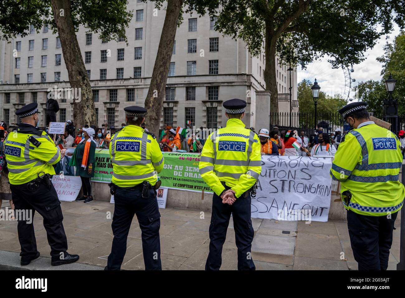 Metropolitan Police Officers kontrollieren eine Schar von Demonstranten, die dagegen protestieren Alassane Ouattara gewinnt eine dritte Amtszeit als Präsident der Elfenbeinküste Küste Stockfoto