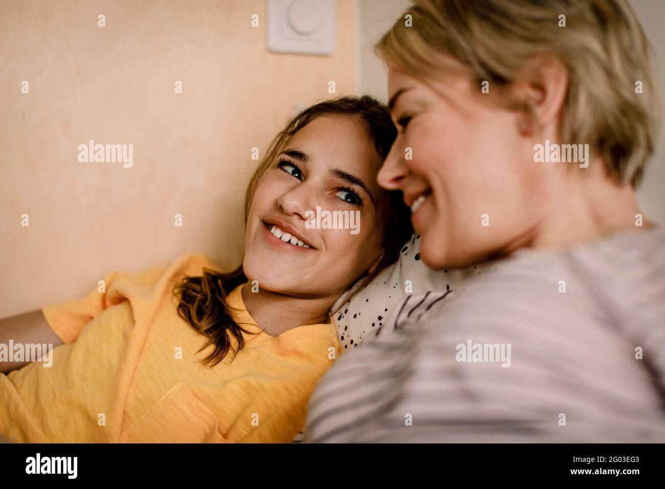 Lächelndes Mädchen, das Mutter im Schlafzimmer ansieht Stockfoto