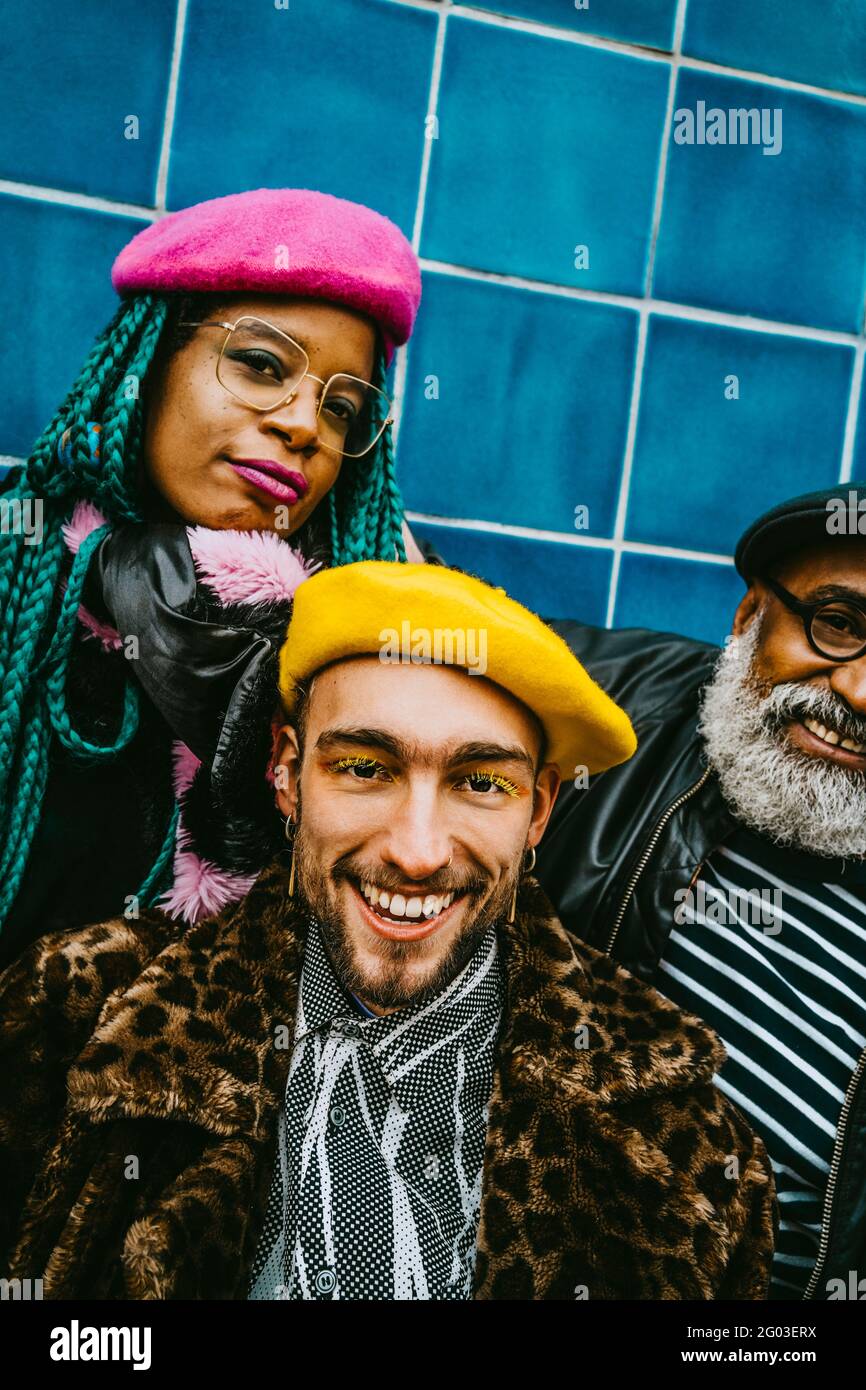 Porträt eines lächelnden jungen Mannes mit Freunden, die Barets tragen Stockfoto