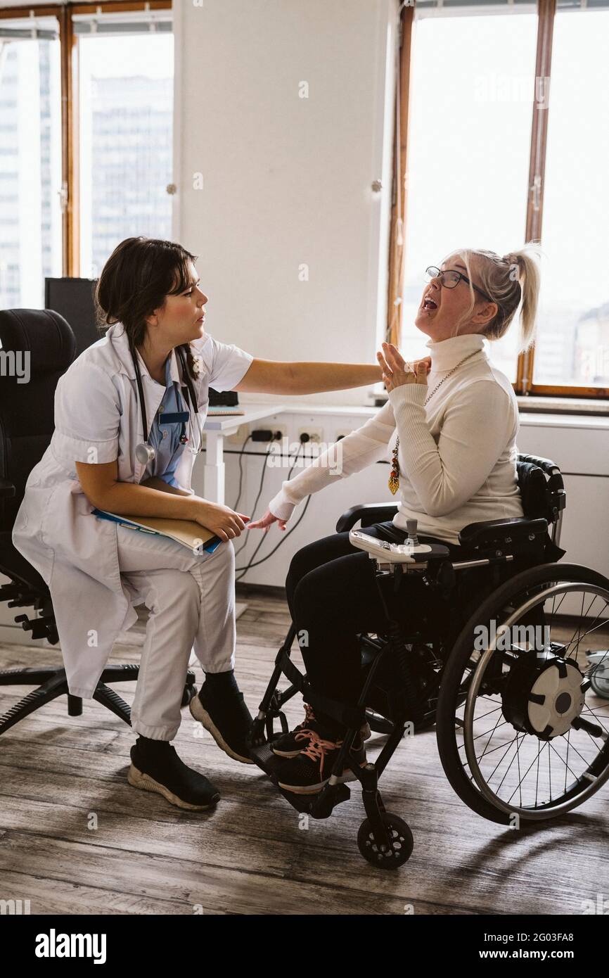 Ärztin, die behinderte Patienten im Rollstuhl in der medizinischen Klinik  untersucht Stockfotografie - Alamy
