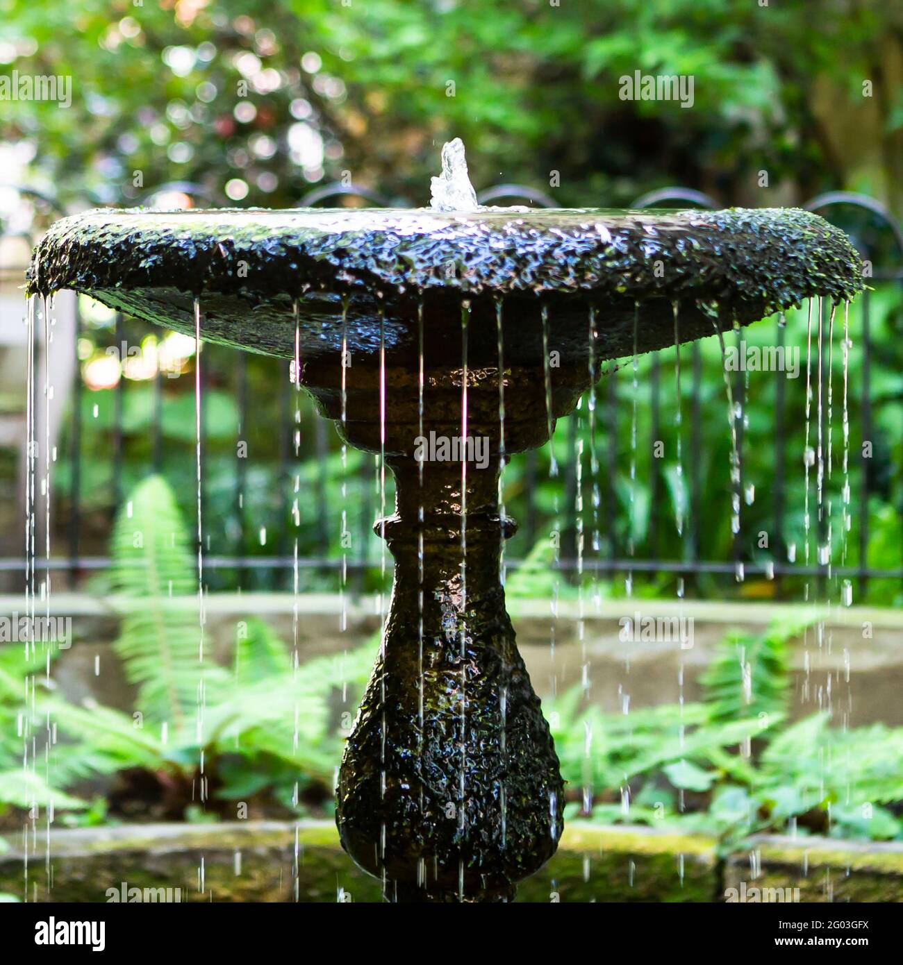 Dekorativer Gartenbrunnen mit verschwommenem Hintergrund Stockfoto