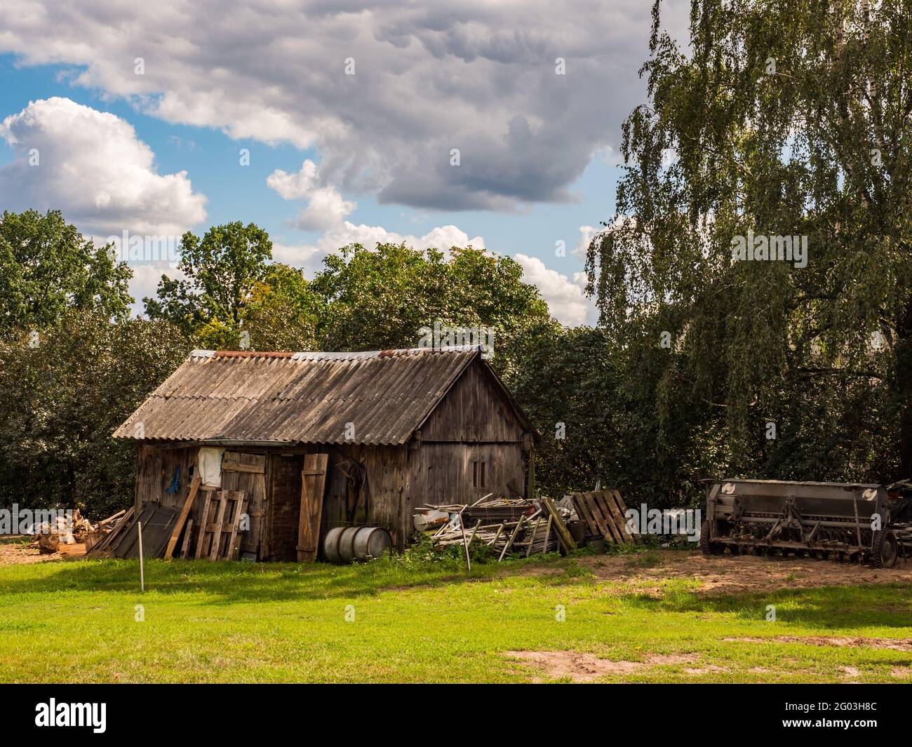 Alte Holzscheune und landwirtschaftliche Geräte in einem ländlichen Hof in Podlasie. Podlachia. Polen, Europa. Die Region heißt Podlasko oder Podlasze Stockfoto