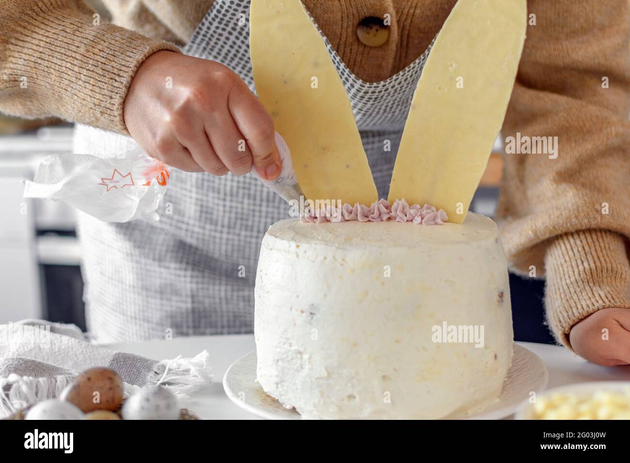 Nahaufnahme eines zugeschnittenen Bildes von Frau, die Kuchen in der Küche zu Hause backen und dekorieren. Stockfoto