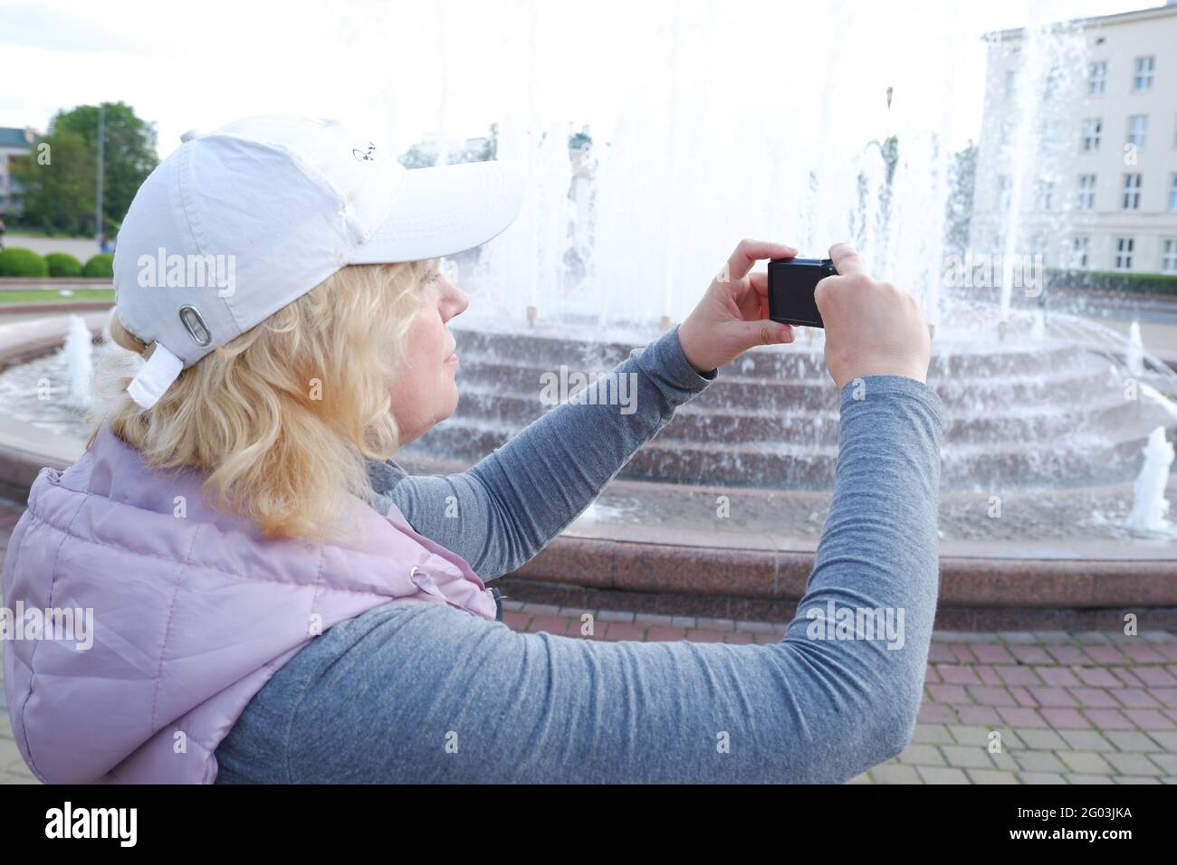 Das Mädchen fotografiert den Stadtbrunnen. St. Veronica's Day Photographer's Day . Stockfoto