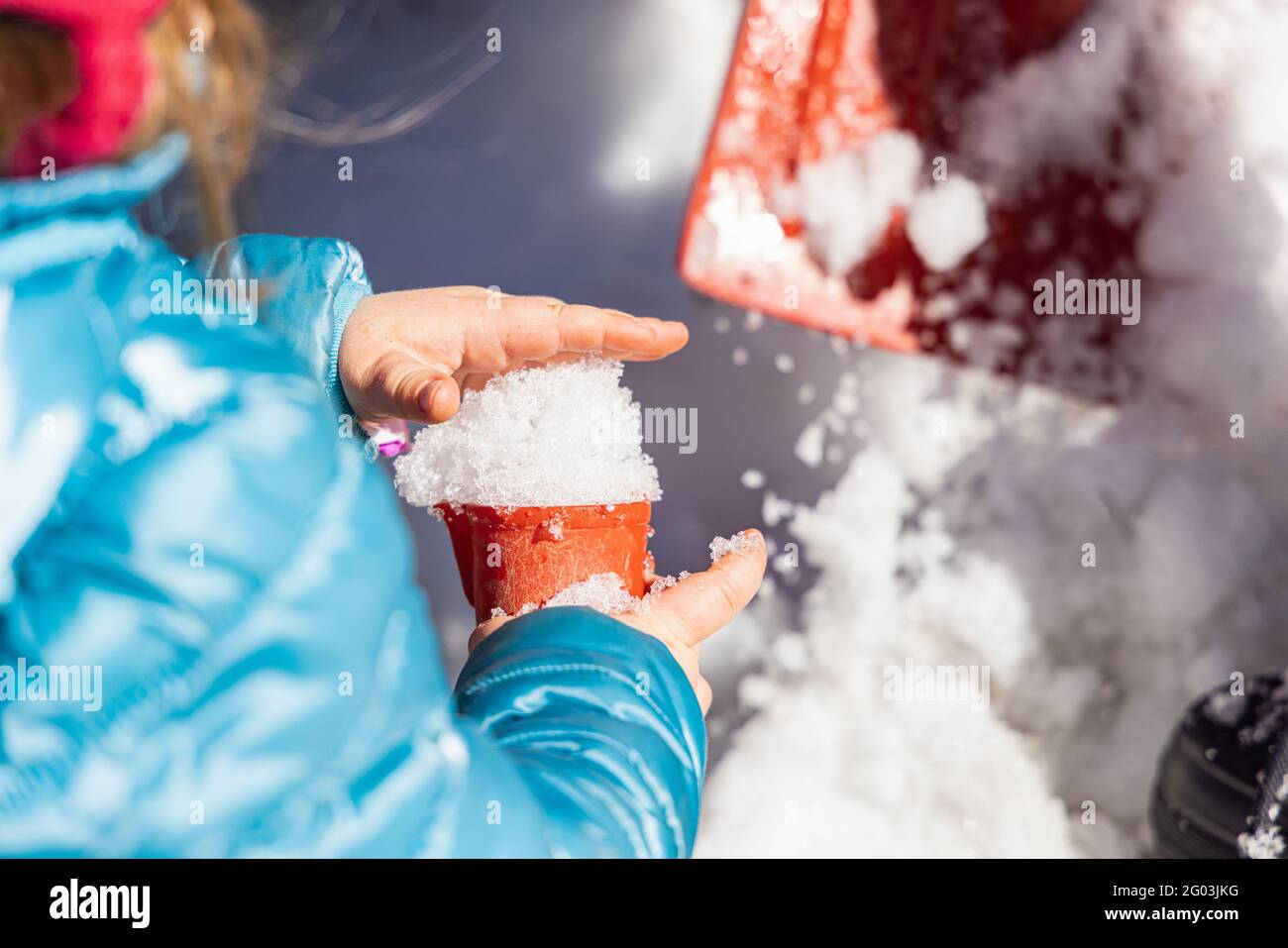 Nahaufnahme von rom über der Hand eines kleinen Kindergartens, das mit dem Schnee im Freiluftspielbereich einer kanadischen Schule spielt. Stockfoto