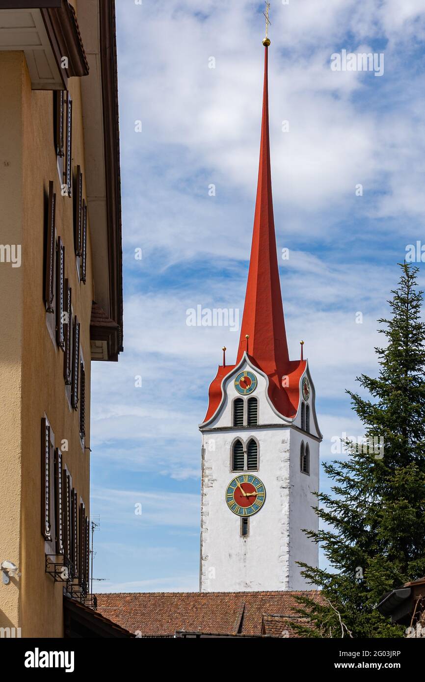 Blick auf die berühmte Stadtkirche Bremgarten mit rotem Ziegeldach und bewölktem Himmel im Frühling. 9. April 2021, Bremgarten - Schweiz. Stockfoto