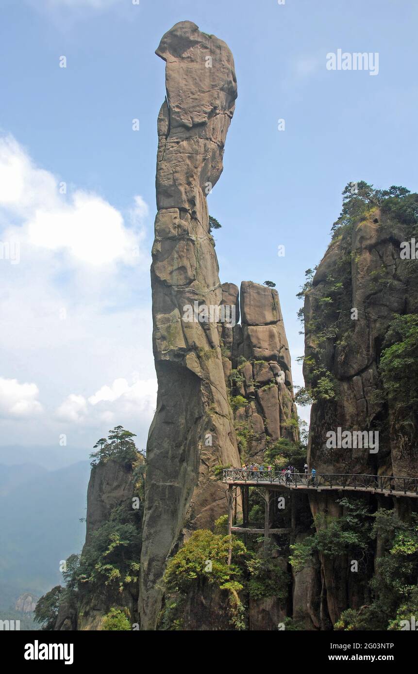 Der Berg Sanqingshan in der Provinz Jiangxi, China. Blick auf Snake Rock oder Python Rock, eine Spitze auf dem Berg Sanqing, mit Pfad und Touristen. Stockfoto