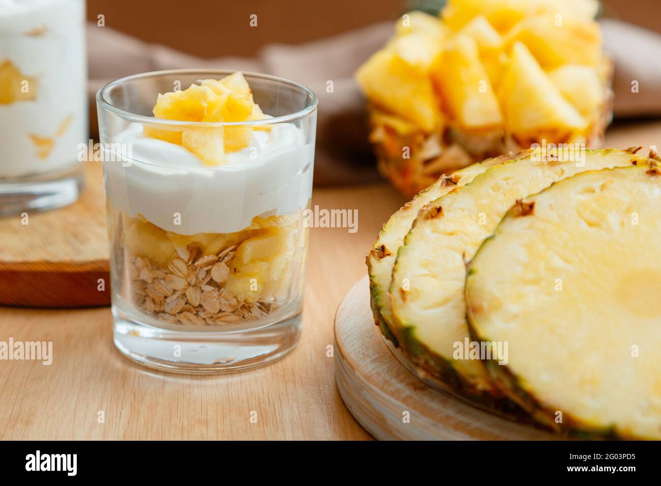 Köstliches Ananasdessert. Frühstücksdessert mit Hafergranola, griechischem Joghurt und Ananas in Glasschichten mit Zutaten frisch saftig gehackt Stockfoto