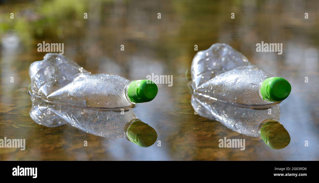 Plastikflaschen, die in einer Wasserpfütze schwimmen. Verschmutzung Müll im Wald. Konzept des Naturschutzes. Stockfoto Plastikflaschen, die in einer Wasserpfütze schwimmen. Verschmutzung Müll im Wald. Konzept des Naturschutzes. Stockfoto