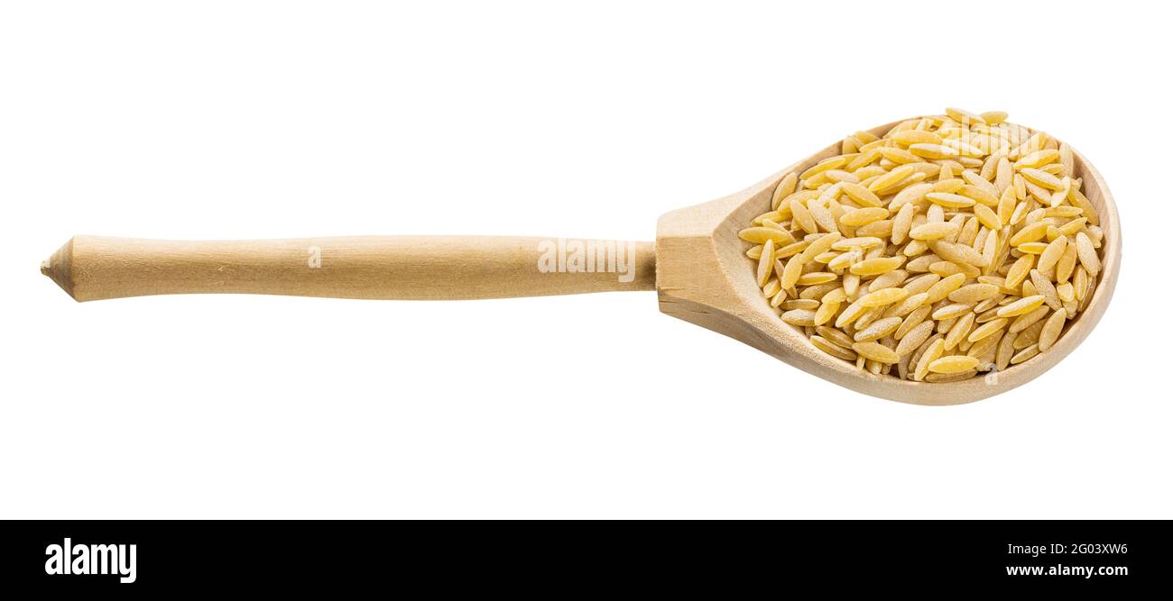 Holzlöffel mit ungekochter, auf Weiß isolierter orzo risoni Pasta Hintergrund Stockfoto