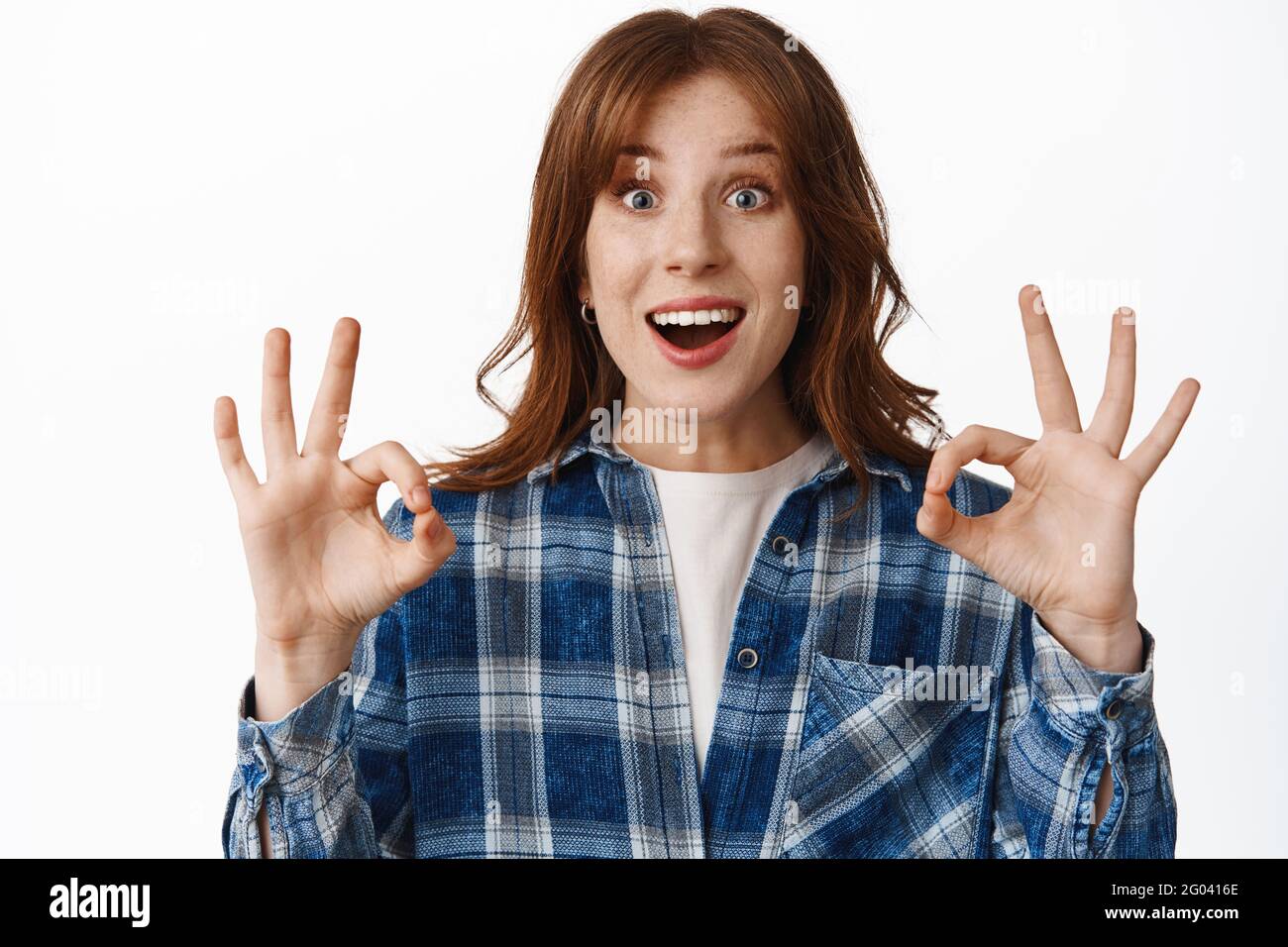 Portrait von aufgeregt Rotschopf Mädchen sagen ja, in Ordnung oder okay, kein Problem, lächeln erstaunt und lobend etwas ehrfürchtiges, genehmigen tolle Sache, stehen Stockfoto