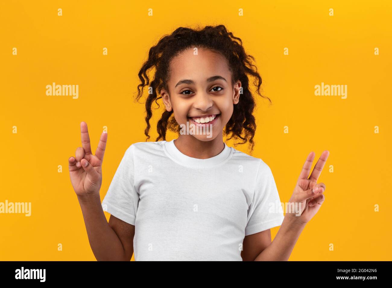 Porträt von lächelnden schwarzen Teenager-Mädchen zeigt Friedenszeichen Stockfoto
