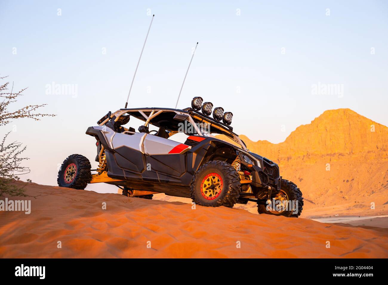 Sharjah, VAE, 16.01.2021. Moderner Dünenbuggy auf Sand in der Wüste mit Bergen im Hintergrund, Fossil Rock, Seitenansicht. Stockfoto