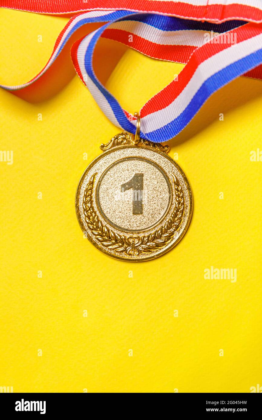 Einfach flach Lay Design Gewinner oder Champion Gold Trophäe Medaille isoliert auf gelb bunten Hintergrund. Sieg erster Platz des Wettbewerbs. Gewinnen oder suc Stockfoto
