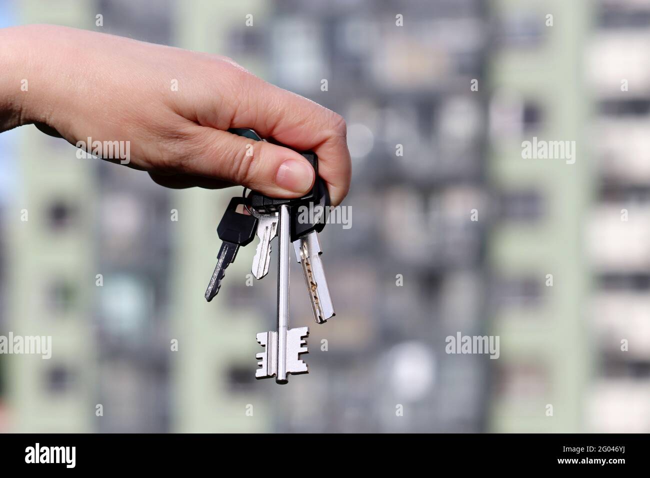 Haus Kauf, Immobilienmakler, Haus, Schlüssel auf dem Hintergrund von neuen Gebäuden. Umzug oder Vermietung Stockfoto